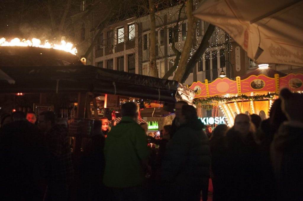 Nachtansicht eines belebten Standes auf dem Weihnachtsmarkt in Köln
